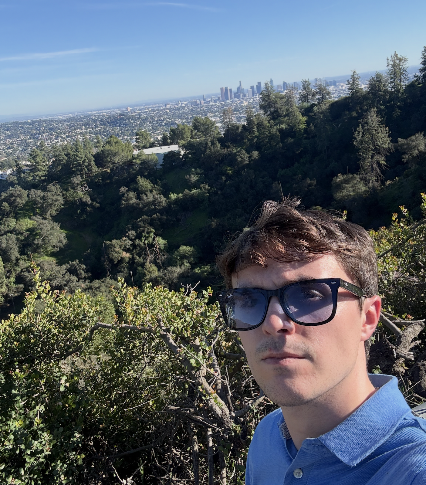 Thomas overlooking a city skyline from a hillside